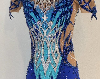 May include: A blue and turquoise leotard with a crystal design. The leotard has short sleeves and a scoop neck. It is decorated with rhinestones and sequins.