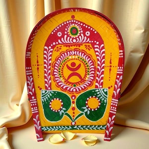 May include: A hand-painted, yellow, decorative basket with red, white, and green accents. The basket features a central design with a stylized human figure, surrounded by floral and geometric patterns. The basket is approximately 18 inches tall.