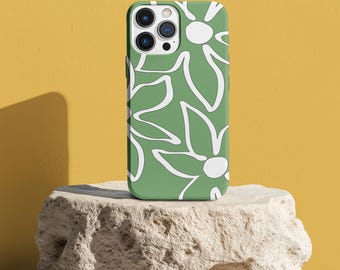 May include: A green phone case with a white floral design. The case is sitting on a light brown rock.
