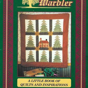 May include: The cover of "The Willow's Warbler" book features a quilt design with green and brown trees and a red house. The cover is framed with a green border and the text "A Little Book of Quilts and Inspirations".