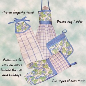 May include: A set of quick kitchen gifts, including a plastic bag holder, a fingertip towel, and two styles of oven mitts. The items are made with a blue and white checkered fabric and feature a grapevine design.