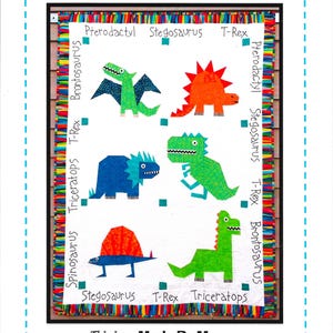 Puede incluir: Un edredón de dinosaurios colorido con ilustraciones de dinosaurios como T-Rex y Stegosaurus. El edredón tiene un fondo blanco con ilustraciones de dinosaurios en verde, naranja y azul. Texto incluye "DINOSAUR QUILT". Hecho por Marney.