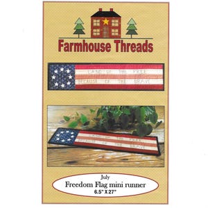 May include: A patriotic July-themed mini runner with a flag design. The runner features the American flag with the text "Land of the Free, Because of the Brave." The runner measures 6.5" x 27". The image also includes the "Farmhouse Threads" logo.