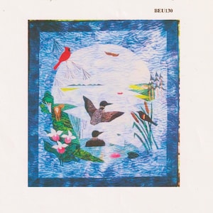 May include: A square fabric quilt featuring a nature scene with a large white moon, a red cardinal on a branch, two loons on blue water, cattails, pink lady slipper flowers, and green trees. The text BEU130 is printed in the top right corner.