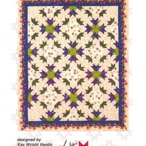 May include: A quilt pattern titled Lily Chain for lap, twin, queen, and king sizes. The design features a repeating star motif in green and blue on a cream background with small floral prints, framed by a blue border with pink flowers.