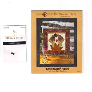 May include: A package of black craft beads and a pattern for a small quilt. The pattern is titled "Little Quilts² Again! November Turkey" by The Wooden Bear Quilt Designs. The quilt design features a turkey with a hat.