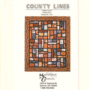 May include: A quilt pattern titled County Lines, Pattern # 274, Pieced Quilt, Design By: Kari. The image shows a rectangular quilt with a central grid of orange, black, and patterned fabric blocks, surrounded by a floral border in orange and black.