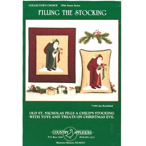 May include: A craft pattern titled FILLING THE STOCKING from the Olde Santa Series by Country Appliques. The cover features a framed wall hanging and a decorative pillow, both depicting Santa Claus holding a stocking, with pine and berry accents.