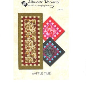 Könnte beinhalten: Ein bedrucktes Stoffmuster mit einem rechteckigen Tischläufer mit einem Trauben- und Blättermuster und zwei quadratischen Quiltblöcken. Der Text "Atkinson Designs" und "Waffle Time" sind sichtbar.