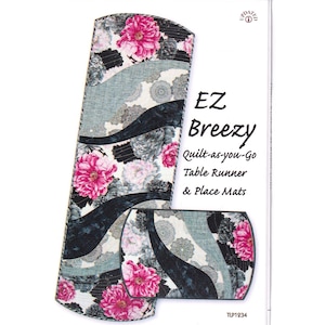 Puede incluir: Un juego de caminos de mesa y manteles individuales con un diseño floral. El juego EZ Breezy presenta peonías rosas, detalles grises y negros. El texto "EZ Breezy Quilt-as-you-Go Table Runner & Place Mats" es visible.