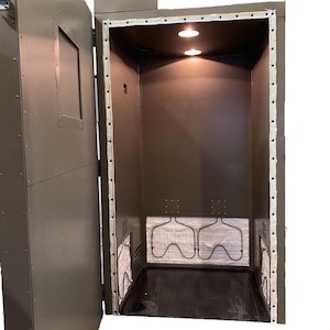May include: A green metal enclosure with a door open, revealing a white insulated interior with three metal heating elements. The enclosure has a small window on the door.