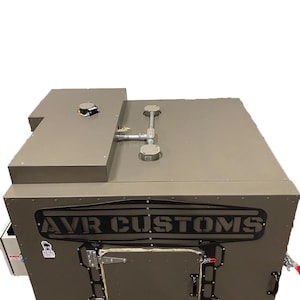 May include: A gray metal box with a black "AVR CUSTOMS" logo on the front. The box has a door with a latch and a handle. There are two vents on the top of the box.