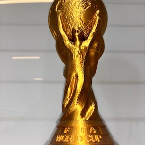 World Cup Trophy 3D print displayed on shelf next to soccer ball – perfect football fan gift and room decor
