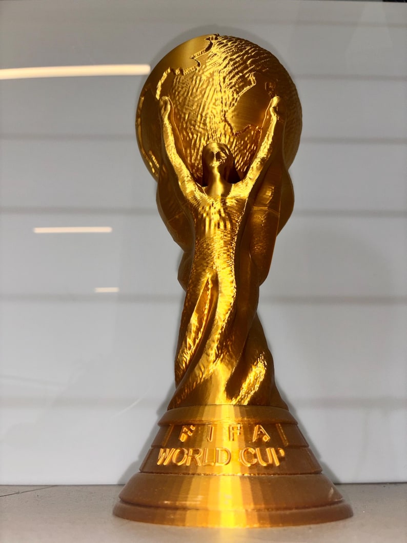 World Cup Trophy 3D print displayed on shelf next to soccer ball – perfect football fan gift and room decor