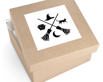 May include: A brown cardboard box with a white sticker featuring a black silhouette of a witch's hat, broom, cauldron, cat, and crescent moon.