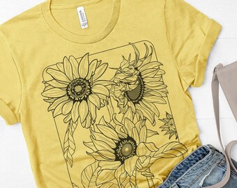 May include: A yellow t-shirt with a black and white graphic of sunflowers. The graphic is in a rectangular frame.