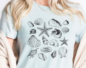 May include: A light blue t-shirt with a black and white illustration of various seashells and starfish.