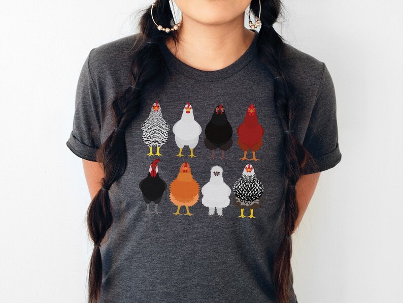 Puede incluir: Una camiseta gris oscuro jaspeada con un gr&aacute;fico de nueve pollos diferentes en varios colores y patrones.