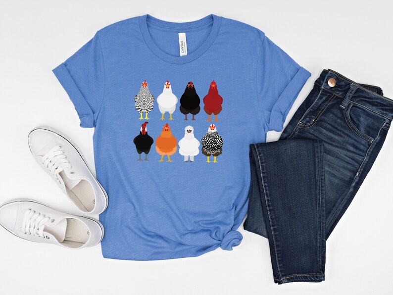 Puede incluir: Una camiseta azul con un gr&aacute;fico de nueve pollos diferentes. Los pollos son de diferentes colores y razas. La camiseta es de estilo casual con cuello redondo y mangas cortas.