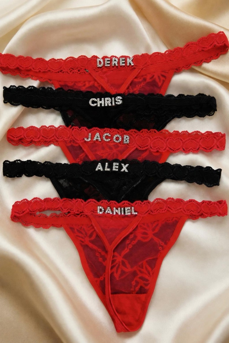 Peut inclure: String en dentelle rouge et noire avec des noms en strass. Les noms "Derek", "Jacob" et "Daniel" sont sur des sous-v&ecirc;tements rouges, tandis que "Chris" et "Alex" sont sur des sous-v&ecirc;tements noirs. La lingerie a une bordure en dentelle d&eacute;licate.