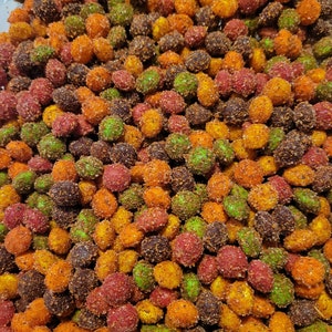 May include: A close-up of a bowl filled with colorful, crunchy, and spicy coated peanuts. The peanuts are a mix of red, orange, green, and brown.