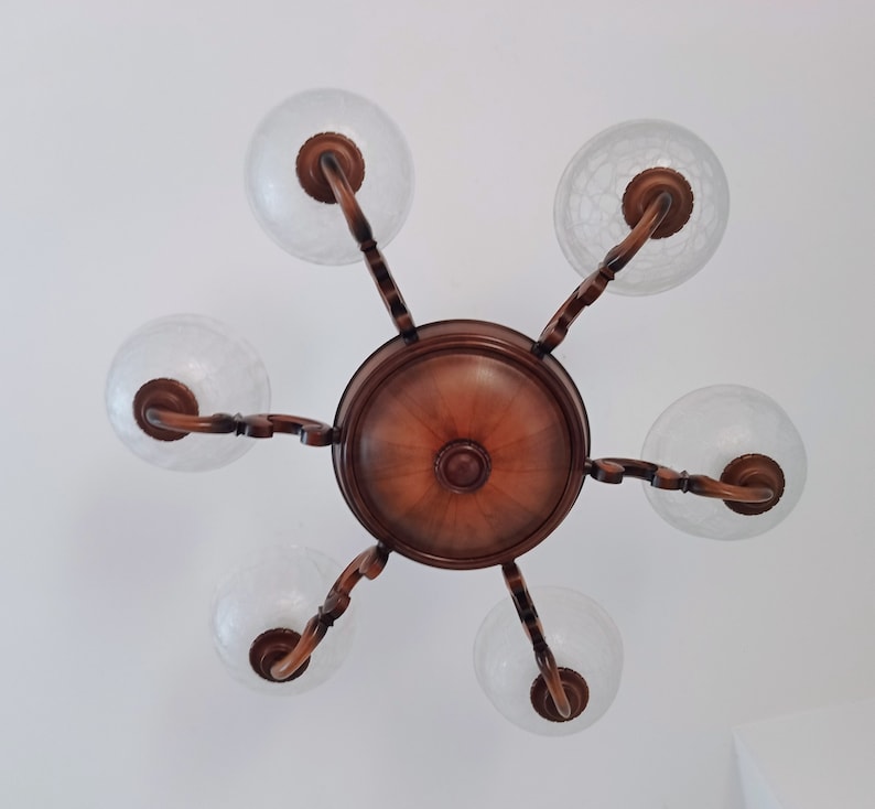 May include: A wooden chandelier with five frosted glass globes. The chandelier has a brown wooden base and arms.