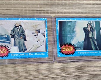 Lote de 2 cromos de Star Wars de primera edición en fundas protectoras, Topps Ben Kenobi, 1977.
