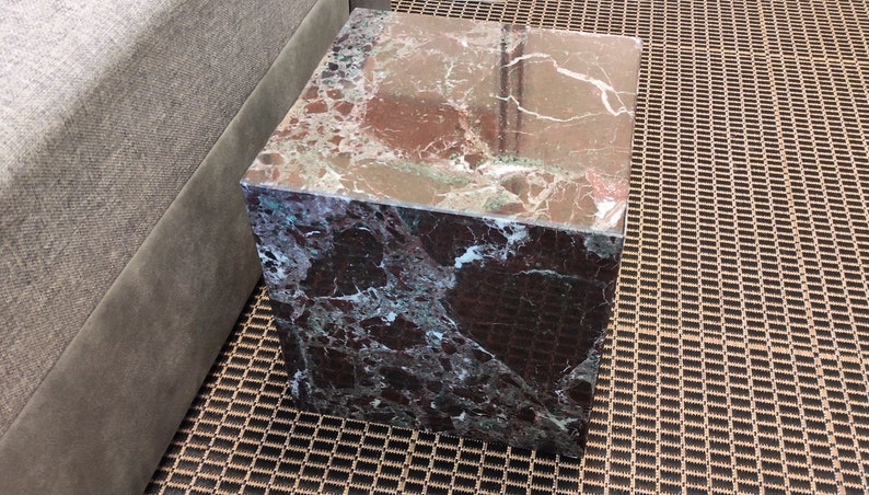 May include: A square, dark green marble end table with a brown and white veined pattern.