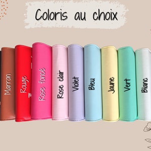 May include: A collection of colorful binders in various shades, including black, brown, red, pink, purple, blue, yellow, green, and white. Each binder is labeled with its color name in French. The phrase "Coloris au choix" is written at the top.