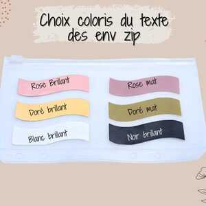May include: A clear zippered pouch displaying color options for text. The options are presented on wavy, pastel-colored labels: pink, gold, white, and black, with corresponding text labels. The text reads "Rose Brillant", "Dor&eacute; brillant", "Blanc brillant", "Rose mat", "Dor&eacute; mat", and "Noir brillant".