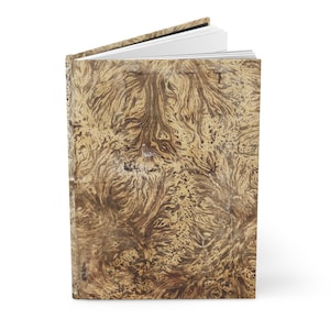 May include: A closed book with a marbled cover in shades of brown and beige. The cover has a unique pattern of swirling lines and dots.
