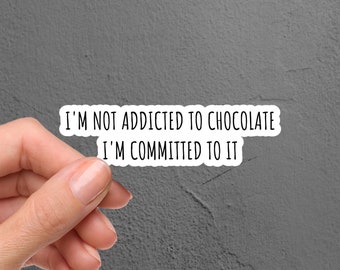 May include: White sticker with black text that reads "I'm not addicted to chocolate I'm committed to it".