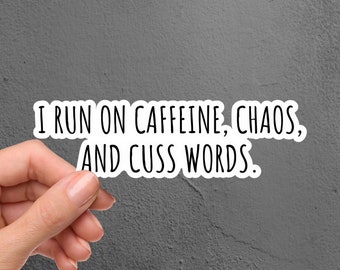 May include: A white sticker with black text that reads "I run on caffeine, chaos, and cuss words."
