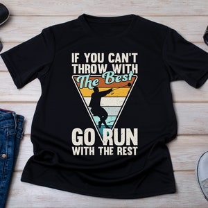 May include: Black t-shirt with a vintage-style graphic design. The graphic features a person throwing a hammer with the text "If you can't throw with the best, go run with the rest".