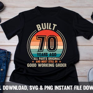 Peut inclure: T-shirt noir avec un graphisme de style vintage qui dit "Built 70 Years Ago All Parts Original and Most Still in Good Working Order".