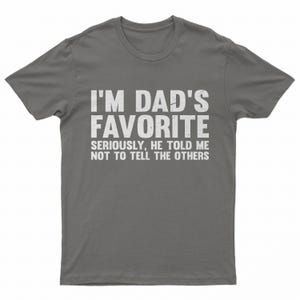 May include: A gray t-shirt with the text "I'M DAD'S FAVORITE" in large white letters. Below, smaller text reads "SERIOUSLY, HE TOLD ME NOT TO TELL THE OTHERS."