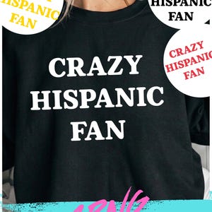 May include: Black sweatshirt with the text "CRAZY HISPANIC FAN" in large white letters. The words are centered on the front of the shirt. The image also includes three circular graphics with the words "CRAZY HISPANIC FAN" in different colors.