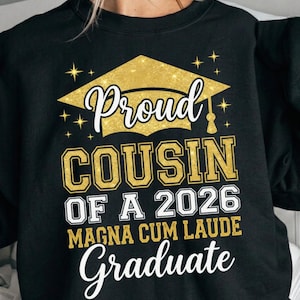 Peut inclure: Sweat-shirt noir avec un motif de chapeau de remise de diplôme doré scintillant et le texte "Proud Cousin of a 2026 Magna Cum Laude Graduate" en lettres blanches et dorées. Le design comprend des étoiles.