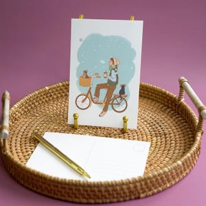 Cartão postal de gatos de bicicleta - garota de moletom andando de bicicleta com 2 gatos e segurando um chá de boba no inverno nevado