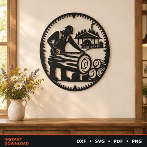 Pode incluir: Uma peça de arte de parede circular em metal preto com a silhueta de um lenhador medindo um tronco. O design inclui uma serração com árvores ao fundo e uma borda dentada. O texto DXF, SVG, PDF, PNG encontra-se na parte inferior.