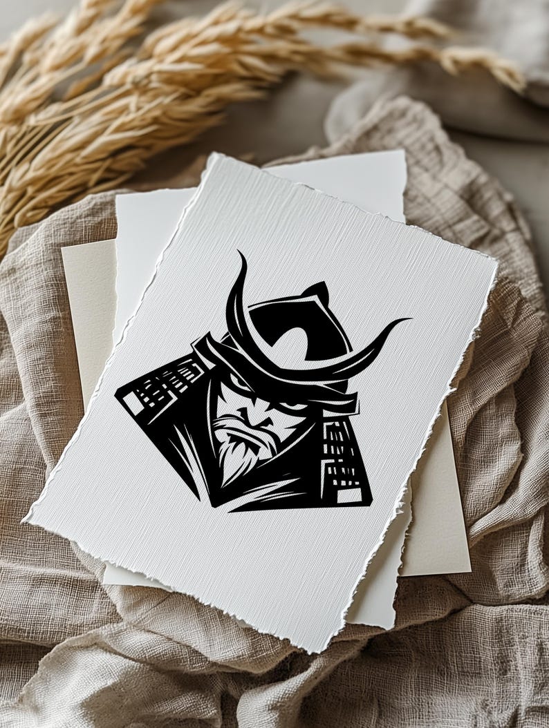 K&ouml;nnte beinhalten: Schwarz-Wei&szlig;-Illustration eines Samurai-Kriegers auf strukturiertem, wei&szlig;em Papier. Der Samurai wird mit Helm und Bart dargestellt. Das Kunstwerk liegt auf einem neutralfarbenen Stoff, was auf einen Druck oder ein Kunstwerk f&uuml;r die Wand hindeutet.