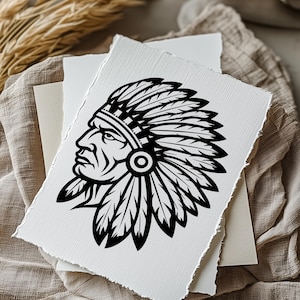 May include: A black and white illustration of a Native American chief in profile, wearing a feathered headdress. The artwork is on a textured, off-white paper with torn edges, layered with other paper on a neutral fabric background.