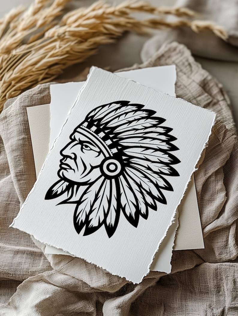 May include: A black and white illustration of a Native American chief in profile, wearing a feathered headdress. The artwork is on a textured, off-white paper with torn edges, layered with other paper on a neutral fabric background.