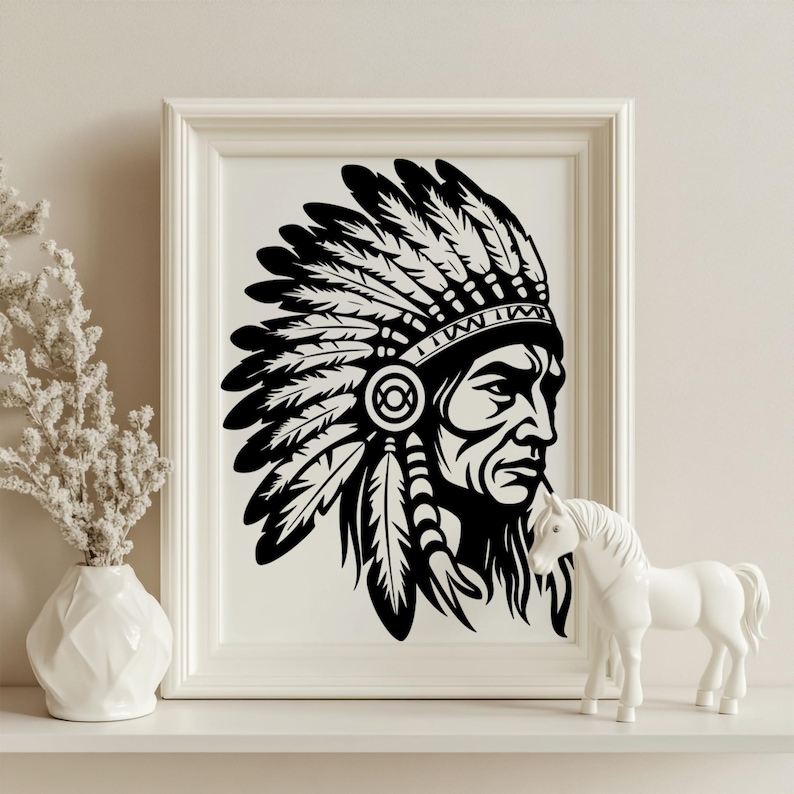May include: Black and white framed print of a Native American chief in profile, wearing a feathered headdress. The artwork is displayed on a white shelf, accompanied by a white vase with dried flowers and a white horse figurine.