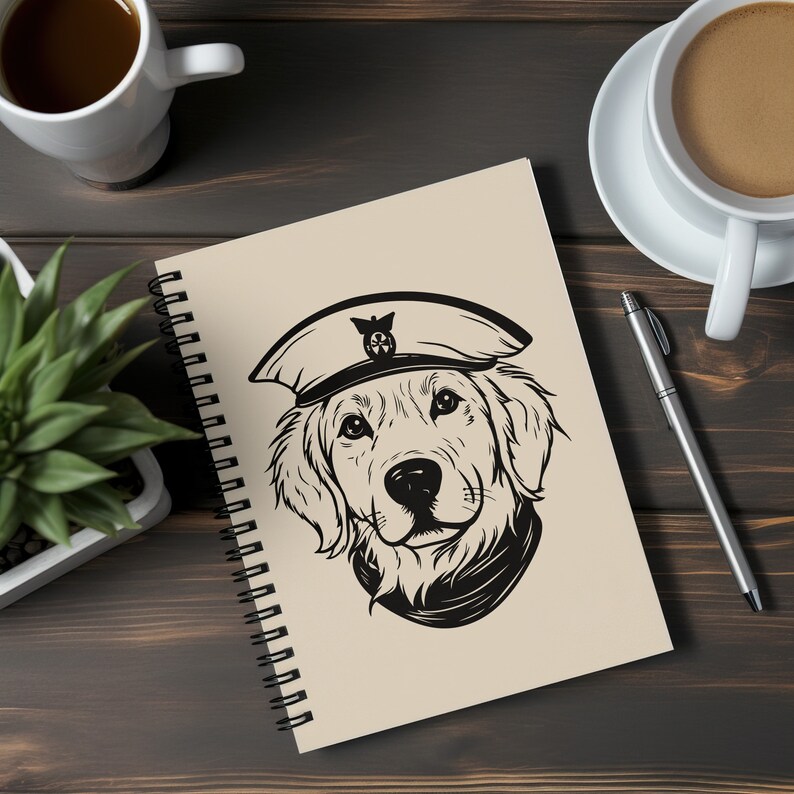 Puede incluir: Una libreta de espiral con una cubierta beige que presenta una ilustraci&oacute;n en blanco y negro de un golden retriever con un gorro de marinero. El perro est&aacute; mirando directamente al espectador.