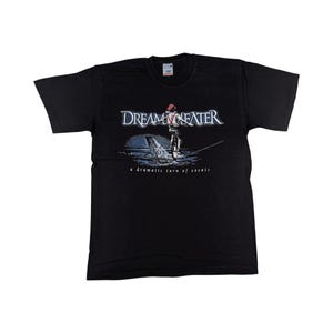 Könnte beinhalten: Schwarzes T-Shirt mit dem Bandnamen "Dream Theater" in weißer Schrift über einer Illustration eines Seiltänzers. Unter der Illustration steht der Text "a dramatic turn of events".