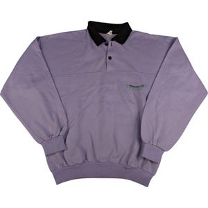 Może przedstawiać: Długi, fioletowy sweter z czarnym kołnierzem i zapięciem na guziki. Sweter ma małe haftowane logo z przodu, które brzmi "Surfside".