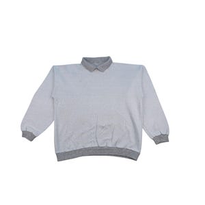 Op de afbeelding: Een lichtgrijs sweatshirt met een grijze kraag, manchetten en tailleband. De top met lange mouwen is gemaakt van een zacht materiaal en ligt plat op een witte achtergrond. De kraag is een polostijl.