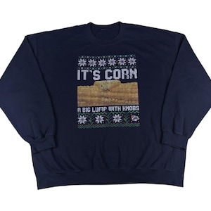Könnte beinhalten: Ein marineblauer Pullover mit einem weißen und grünen Weihnachtsdesign mit dem Text "It's Corn. A Big Lump With Knobs".