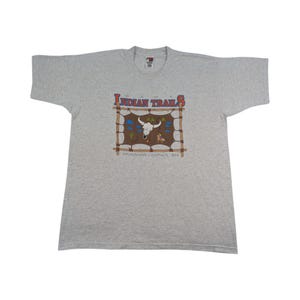 Könnte beinhalten: Ein meliertes graues T-Shirt mit dem Schriftzug "Indian Trails" in Rot und Braun. Das T-Shirt hat eine Grafik eines Bullenschädels, eines Tipis und den Text "Sinnissippi Council, BSA".